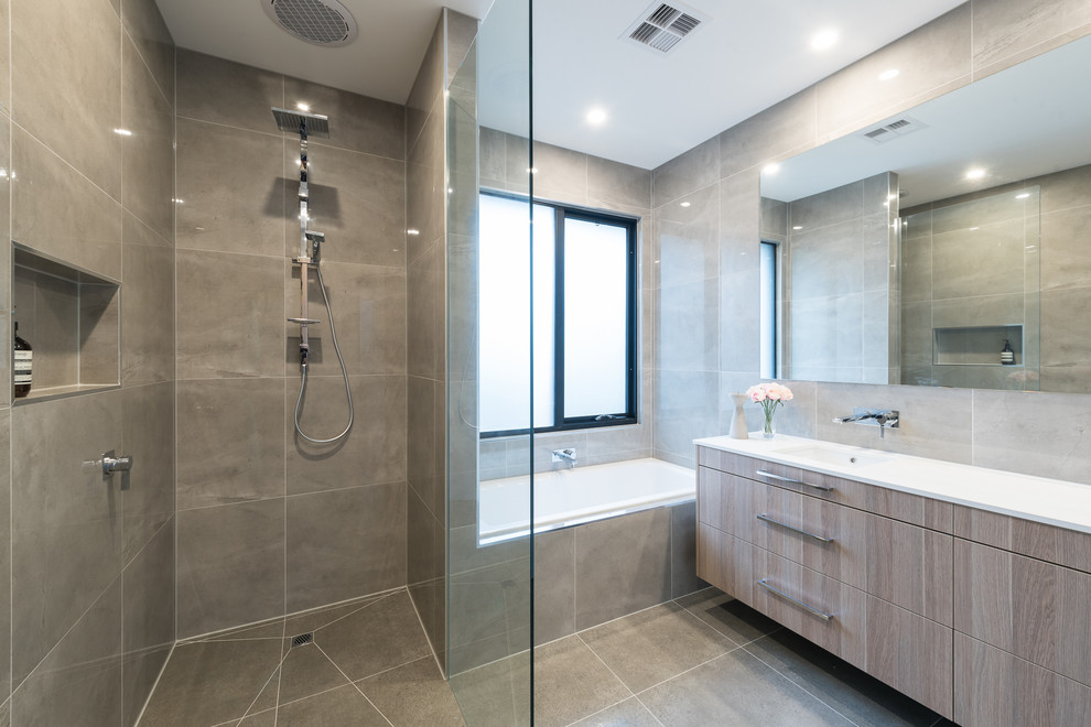 Photo of a mid-sized contemporary kids bathroom in Melbourne with a drop-in tub, a curbless shower, beige tile, grey walls, an integrated sink, an open shower and white benchtops.