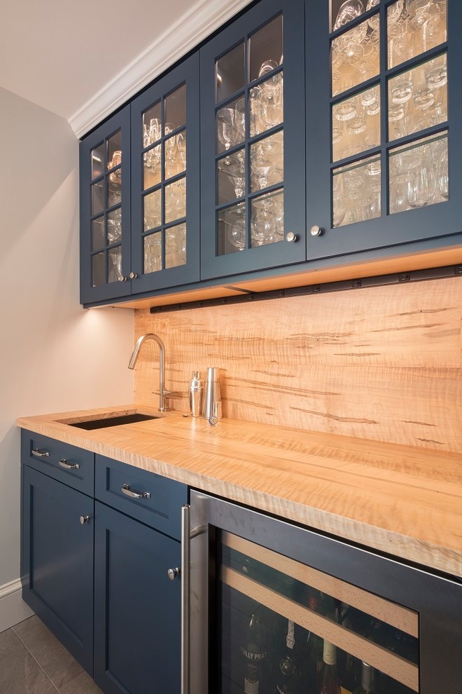 This is an example of a mid-sized transitional u-shaped separate kitchen in DC Metro with shaker cabinets, blue cabinets, wood benchtops, yellow splashback, timber splashback, stainless steel appliances, ceramic floors, a peninsula, grey floor and yellow benchtop.