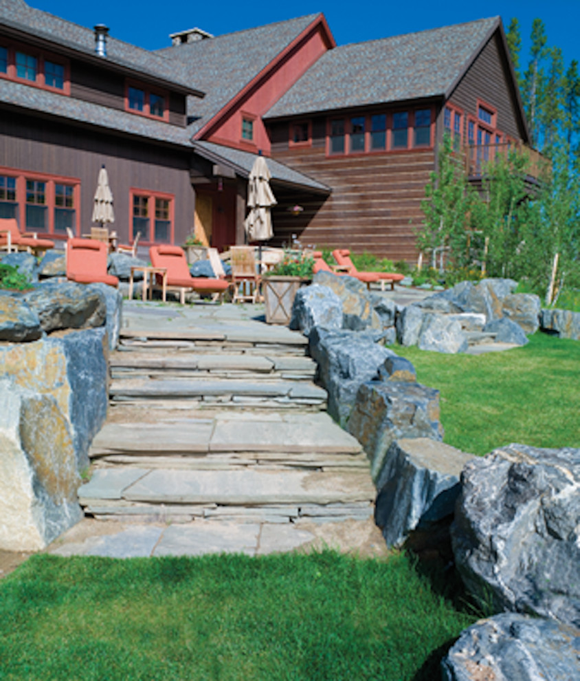 This is an example of a mid-sized rustic full sun backyard stone landscaping in Denver for summer.