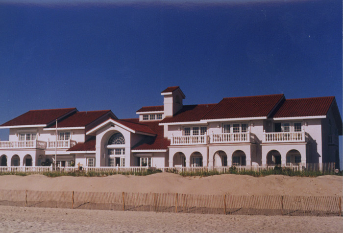 Example of a huge beach style beige three-story stucco exterior home design in Baltimore