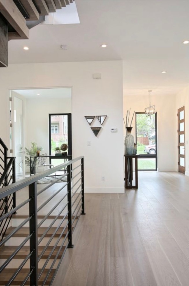 Inspiration for a large modern hallway in Denver with white walls, medium hardwood floors and beige floor.
