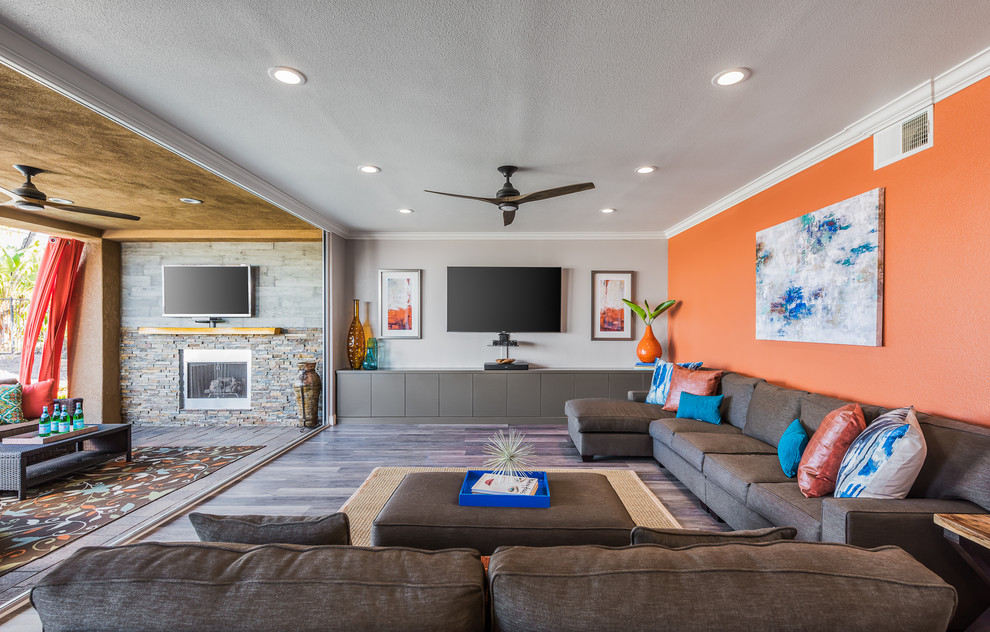 Transitional open concept family room in San Diego with orange walls and a wall-mounted tv.