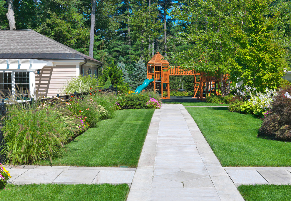 Large traditional garden in Boston with with outdoor playset.