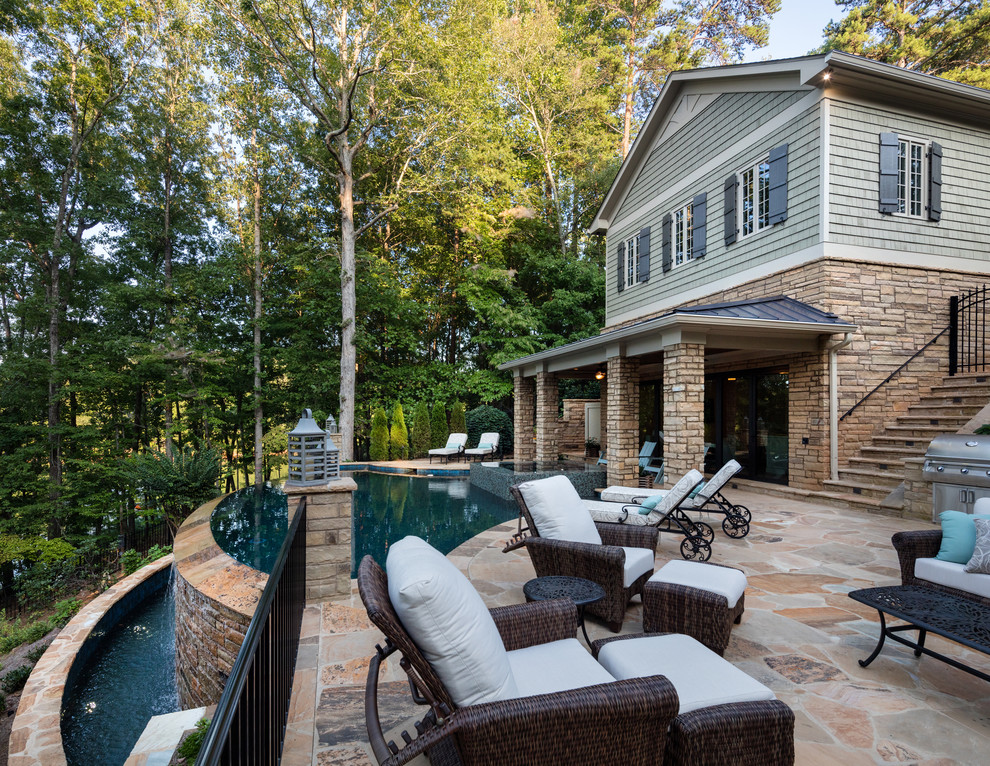 This is an example of a mid-sized traditional backyard patio in Atlanta with no cover, an outdoor kitchen and natural stone pavers.