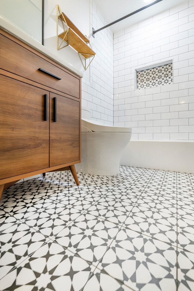 This is an example of a small midcentury master bathroom in DC Metro with flat-panel cabinets, a shower/bathtub combo, a one-piece toilet, white tile, ceramic tile, grey walls, solid surface benchtops, multi-coloured floor, a shower curtain, white benchtops, a niche, a single vanity, a freestanding vanity, medium wood cabinets, an alcove tub, porcelain floors and a drop-in sink.
