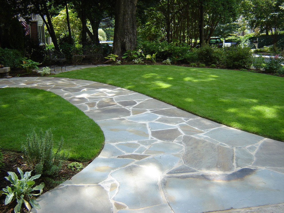 This is an example of a traditional front yard garden in Atlanta with natural stone pavers.