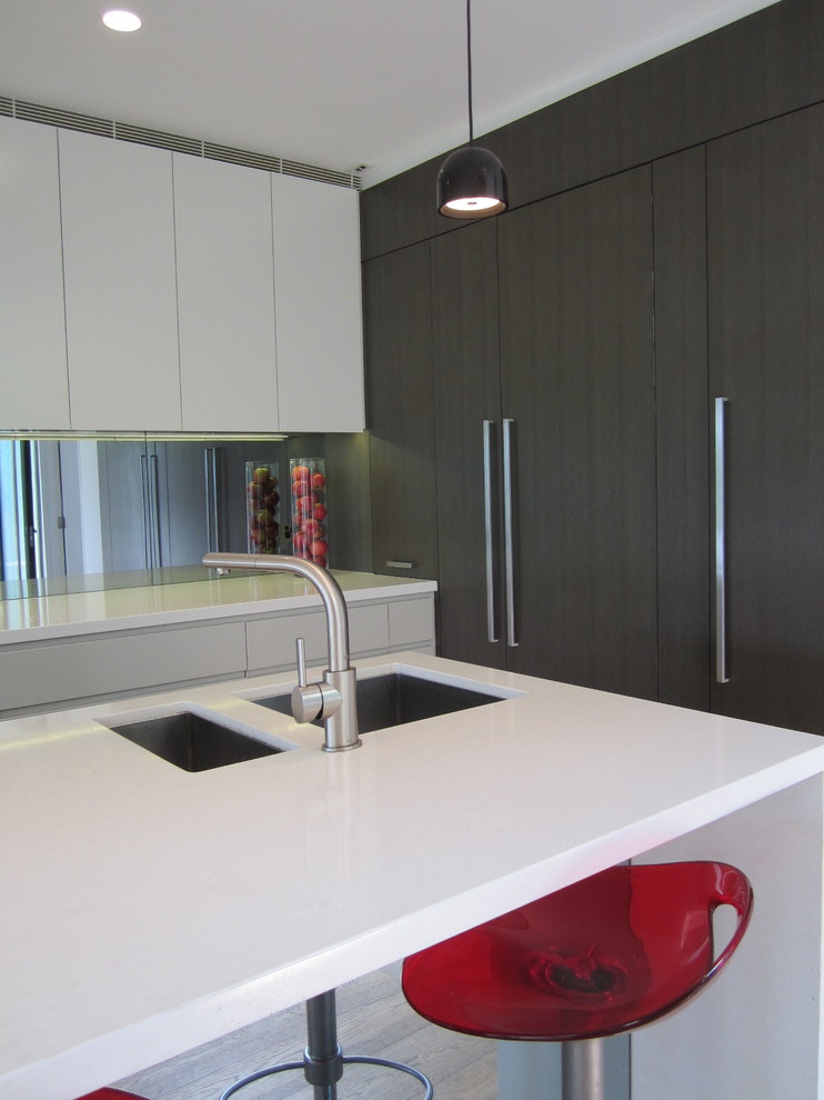 Design ideas for a mid-sized contemporary l-shaped kitchen in Sydney with an undermount sink, flat-panel cabinets, grey cabinets, solid surface benchtops, stainless steel appliances and with island.
