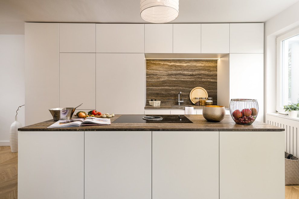 Zweizeilige, Kleine Moderne grifflose Küche mit Unterbauwaschbecken, flächenbündigen Schrankfronten, weißen Schränken, Küchenrückwand in Braun, hellem Holzboden, Kücheninsel, beigem Boden und brauner Arbeitsplatte in München