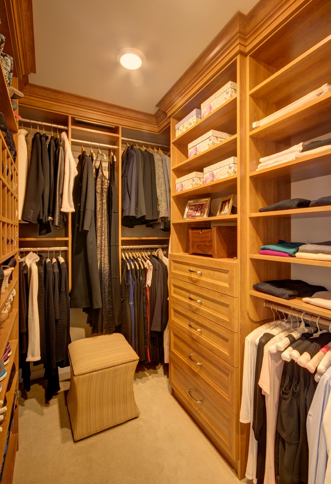 Mid-sized traditional gender-neutral walk-in wardrobe in New York with open cabinets, light wood cabinets, carpet and beige floor.