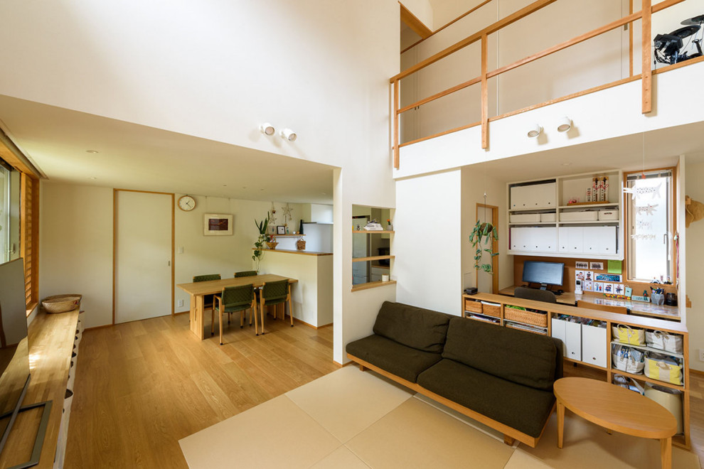 Стильный дизайн: открытая гостиная комната с белыми стенами, татами, потолком с обоями и обоями на стенах - последний тренд