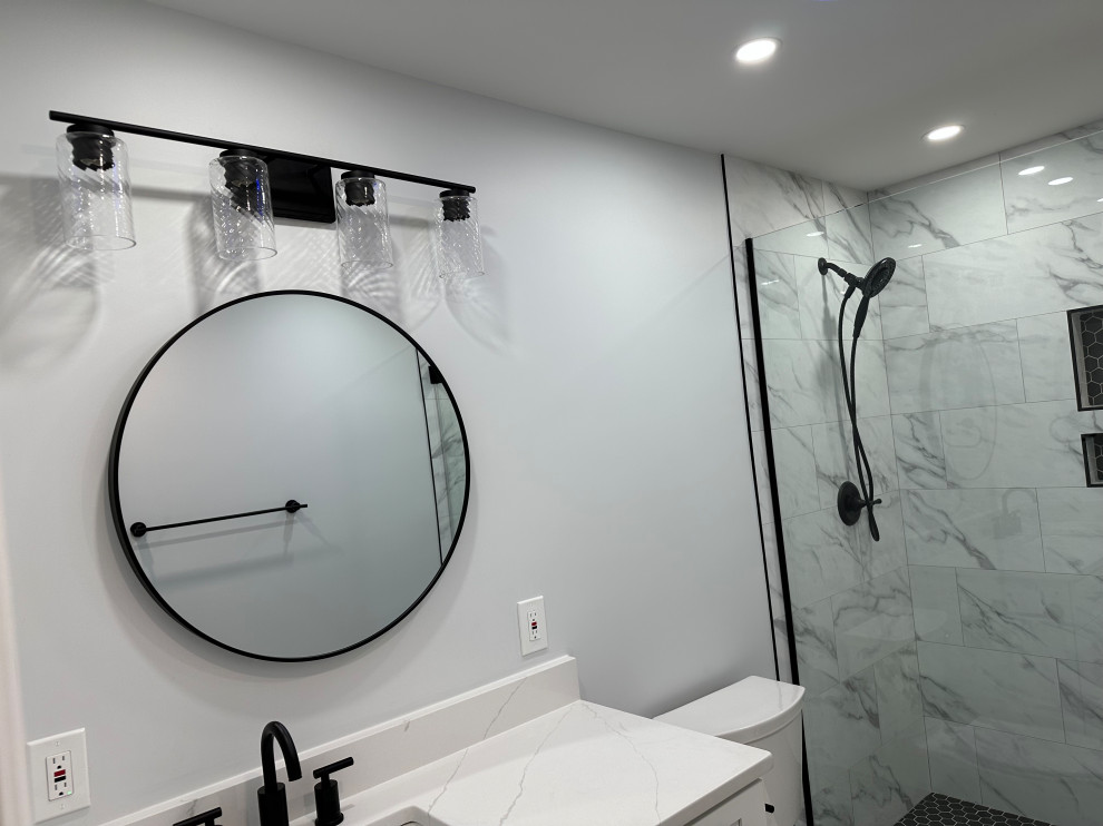 Mid-sized modern master bathroom in DC Metro with shaker cabinets, white cabinets, an alcove shower, a two-piece toilet, white tile, porcelain tile, grey walls, porcelain floors, an undermount sink, quartzite benchtops, grey floor, a hinged shower door, white benchtops, a niche, a single vanity and a built-in vanity.
