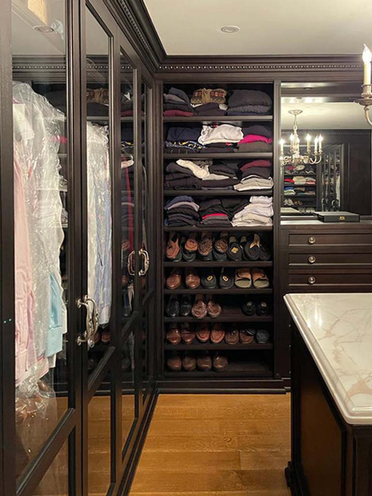Design ideas for a mid-sized traditional men's walk-in wardrobe in New York with shaker cabinets, dark wood cabinets, medium hardwood floors, brown floor and recessed.