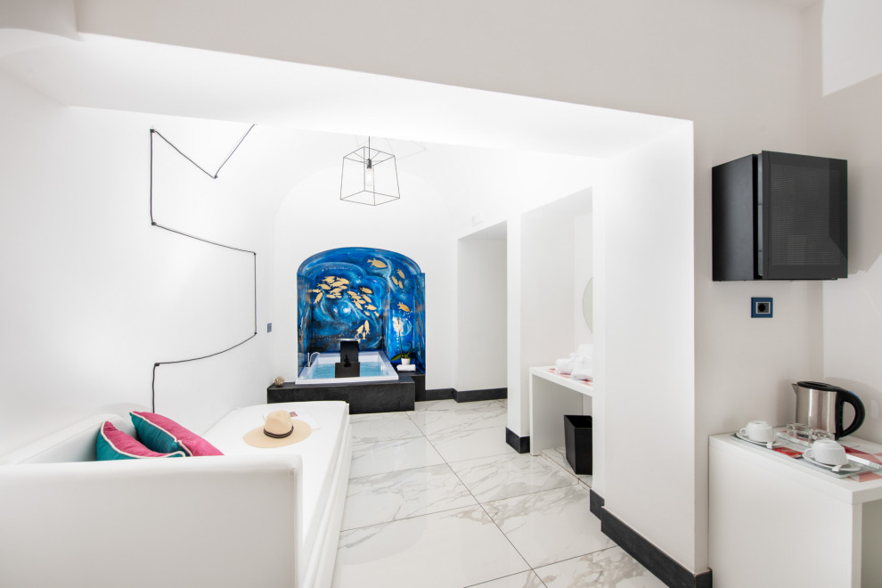Modelo de dormitorio principal, abovedado y televisión mediterráneo grande con paredes blancas, suelo de baldosas de cerámica y suelo beige