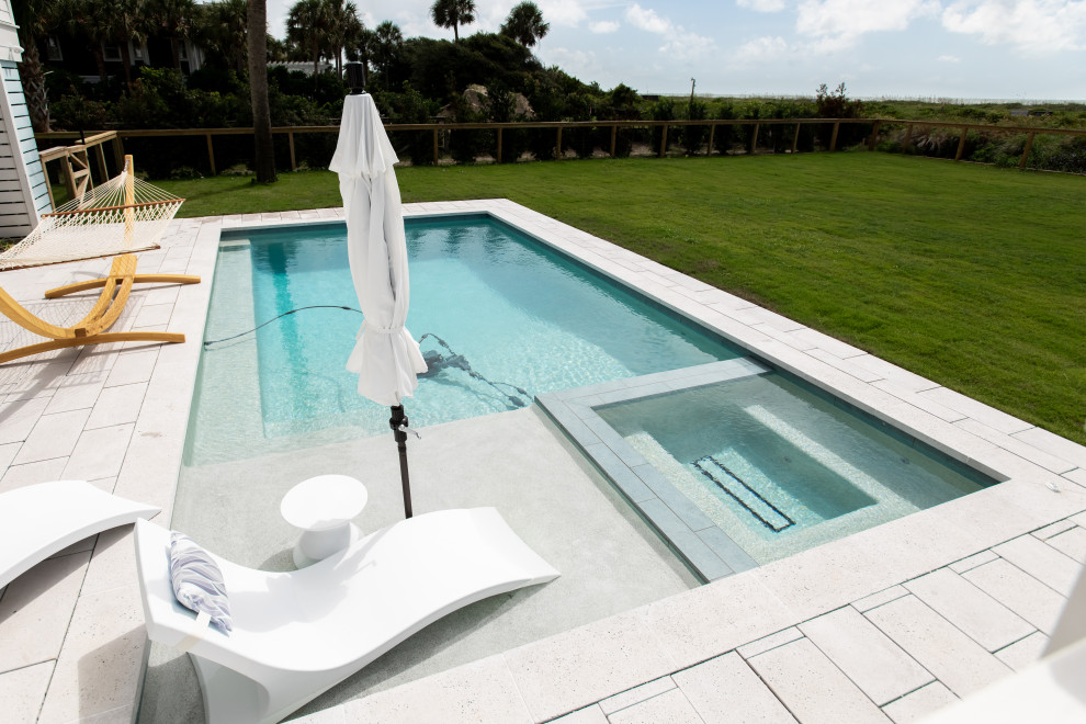 Foto di una piscina stile marinaro rettangolare di medie dimensioni e dietro casa con una vasca idromassaggio e pavimentazioni in cemento