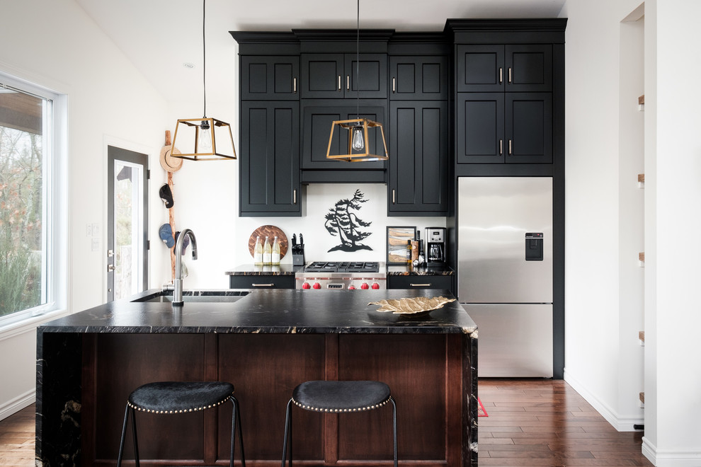 Inspiration for a transitional kitchen in Toronto with an undermount sink, shaker cabinets, black cabinets, stainless steel appliances, dark hardwood floors, with island, brown floor and granite benchtops.