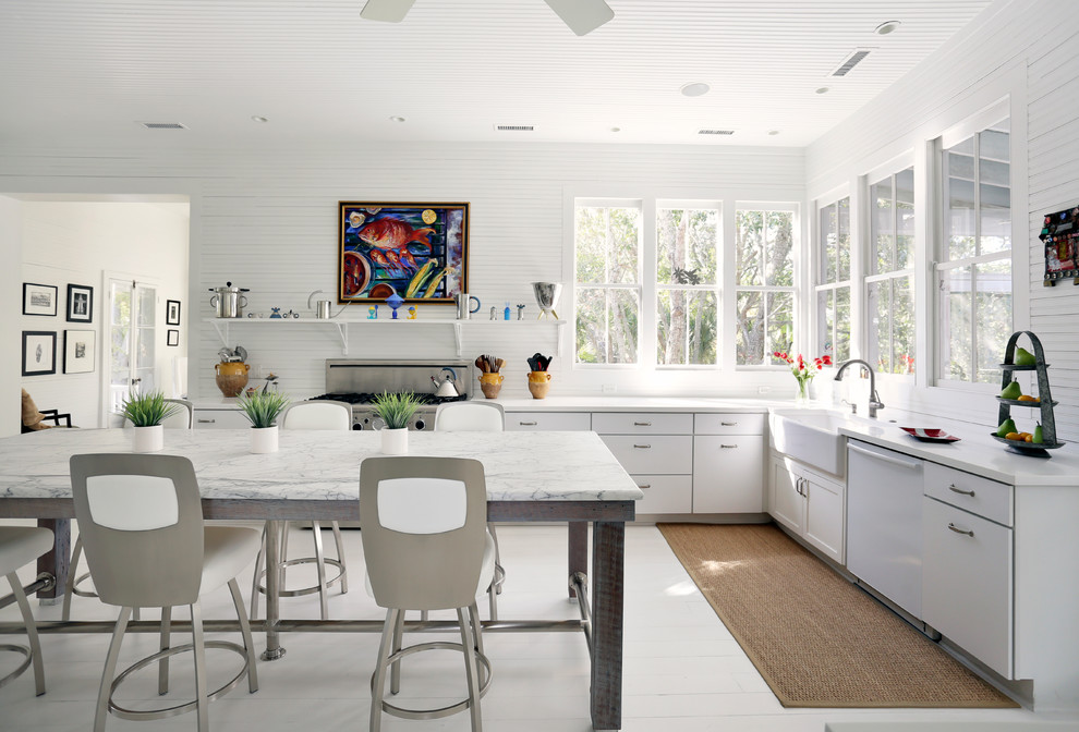 Design ideas for a traditional l-shaped eat-in kitchen in San Francisco with a farmhouse sink, flat-panel cabinets, white cabinets, stainless steel appliances and white floor.