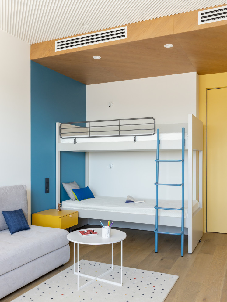Exempel på ett mellanstort modernt könsneutralt barnrum kombinerat med sovrum och för 4-10-åringar, med mellanmörkt trägolv