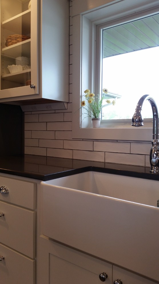 Inspiration for a transitional galley dark wood floor eat-in kitchen remodel with white cabinets, granite countertops, white backsplash, subway tile backsplash and stainless steel appliances