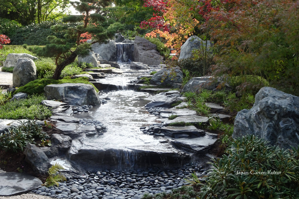 Inspiration for a mid-sized asian side yard garden for fall in Hanover with with waterfall.