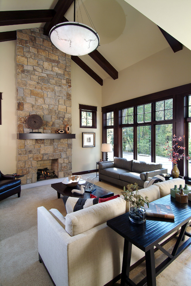 Traditional open concept living room in Grand Rapids with beige walls, a standard fireplace and a stone fireplace surround.