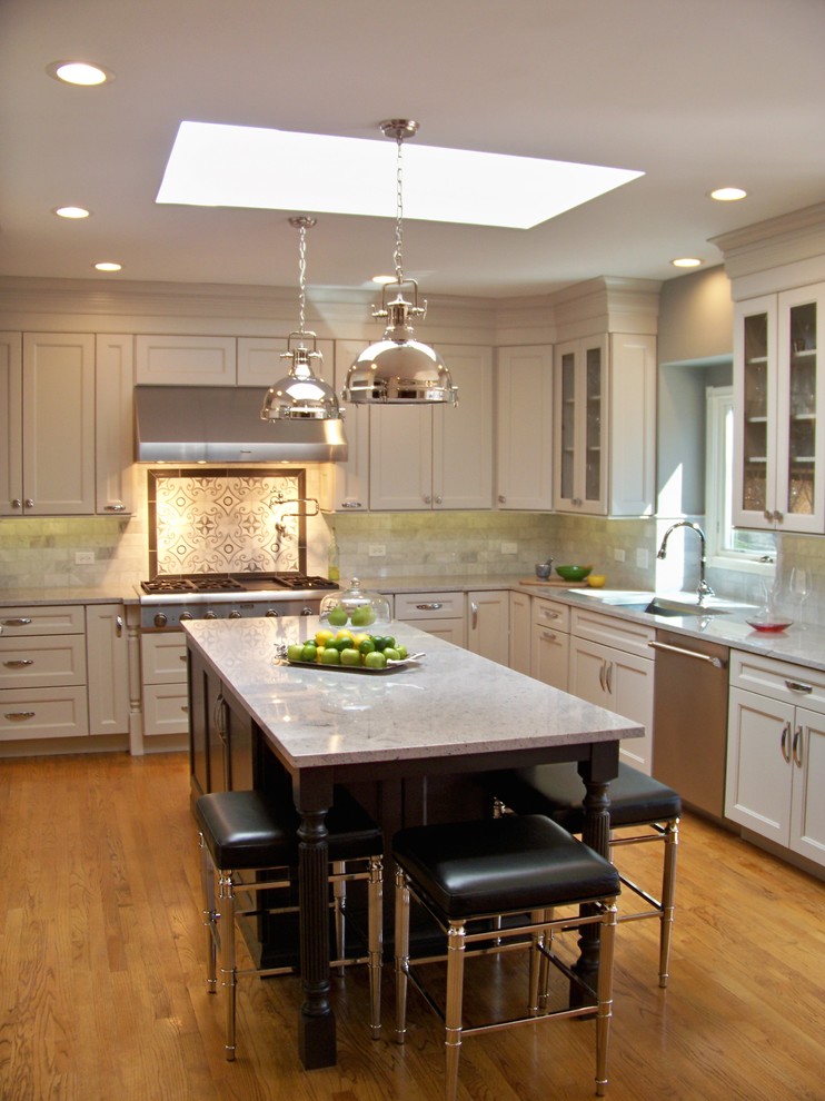 Example of a mid-sized transitional u-shaped medium tone wood floor and brown floor eat-in kitchen design in Chicago with an undermount sink, recessed-panel cabinets, white cabinets, quartz countertops, white backsplash, porcelain backsplash, stainless steel appliances and an island