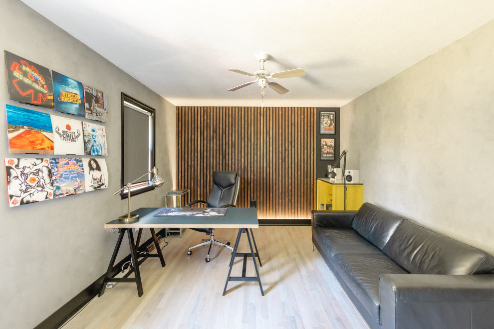 Mittelgroßes Modernes Arbeitszimmer mit Arbeitsplatz, grauer Wandfarbe, hellem Holzboden, freistehendem Schreibtisch, grauem Boden und Holzwänden in Sonstige