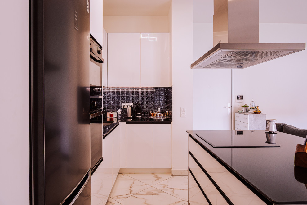 Idee per una cucina moderna di medie dimensioni con lavello integrato, ante a filo, pavimento in marmo, top nero, top in granito, paraspruzzi con piastrelle a mosaico, pavimento bianco, ante bianche, paraspruzzi blu e elettrodomestici neri