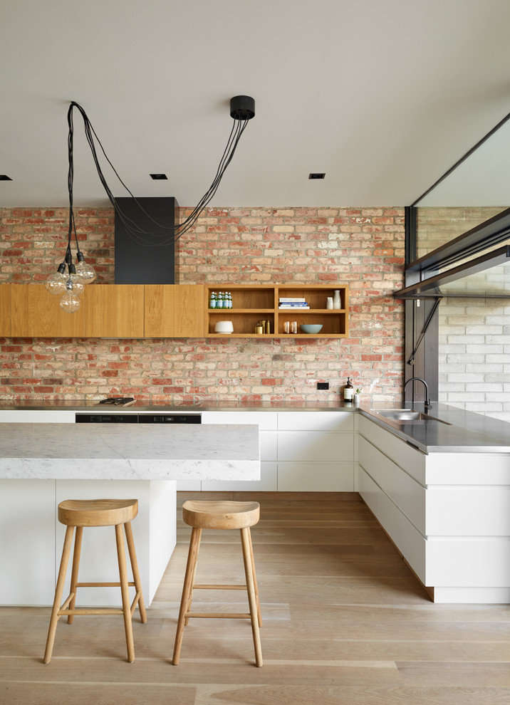 Large transitional l-shaped kitchen pantry in Melbourne with a double-bowl sink, beaded inset cabinets, black cabinets, marble benchtops, brick splashback and with island.