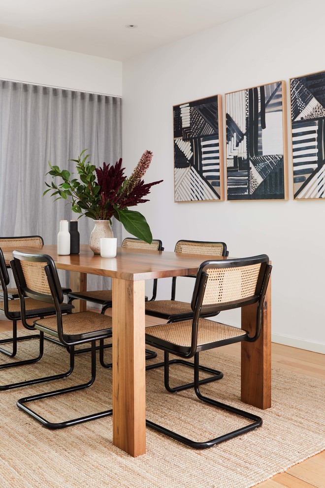 This is an example of a mid-sized scandinavian dining room in Melbourne with white walls, light hardwood floors, no fireplace and brown floor.