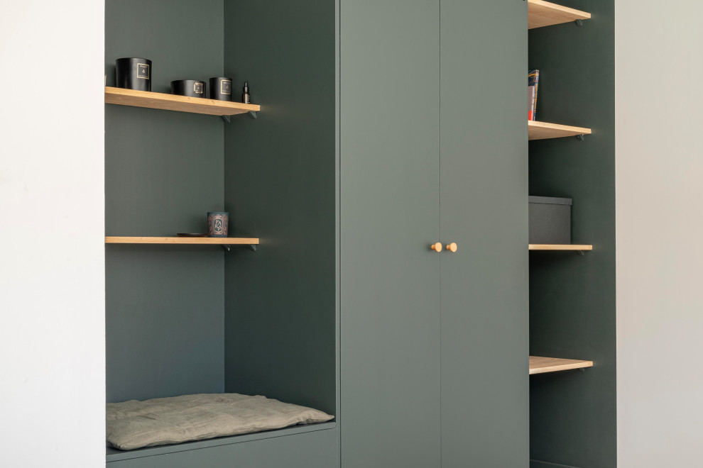 Foto di un soggiorno minimalista con libreria e pareti verdi