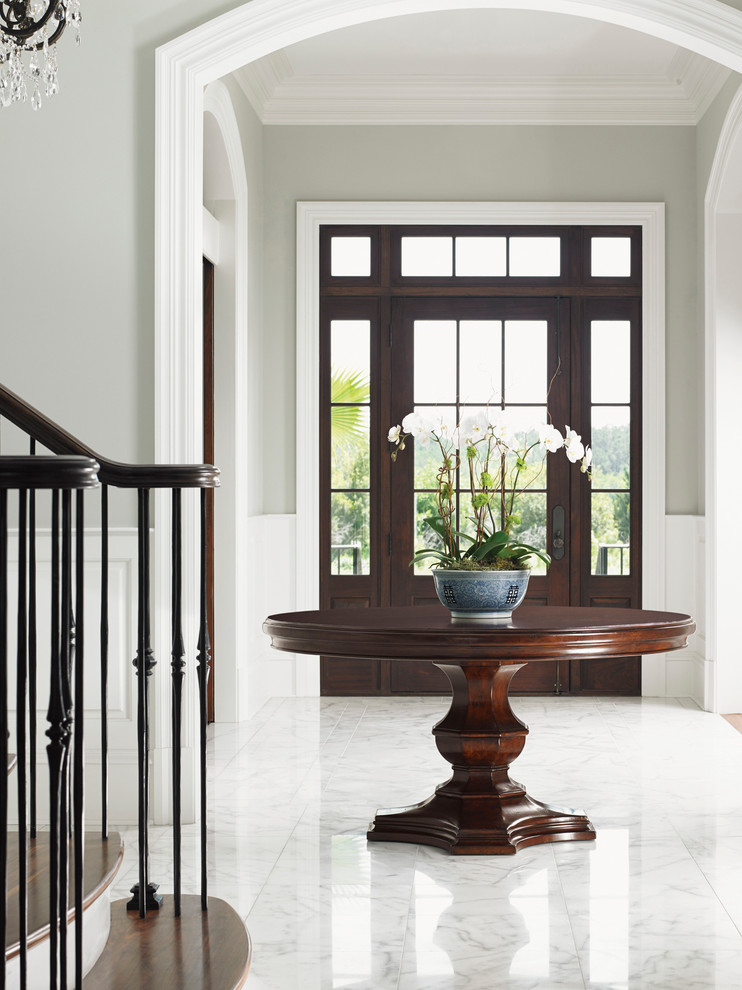 This is an example of a mid-sized traditional foyer in Orange County with grey walls, marble floors, a single front door and a brown front door.