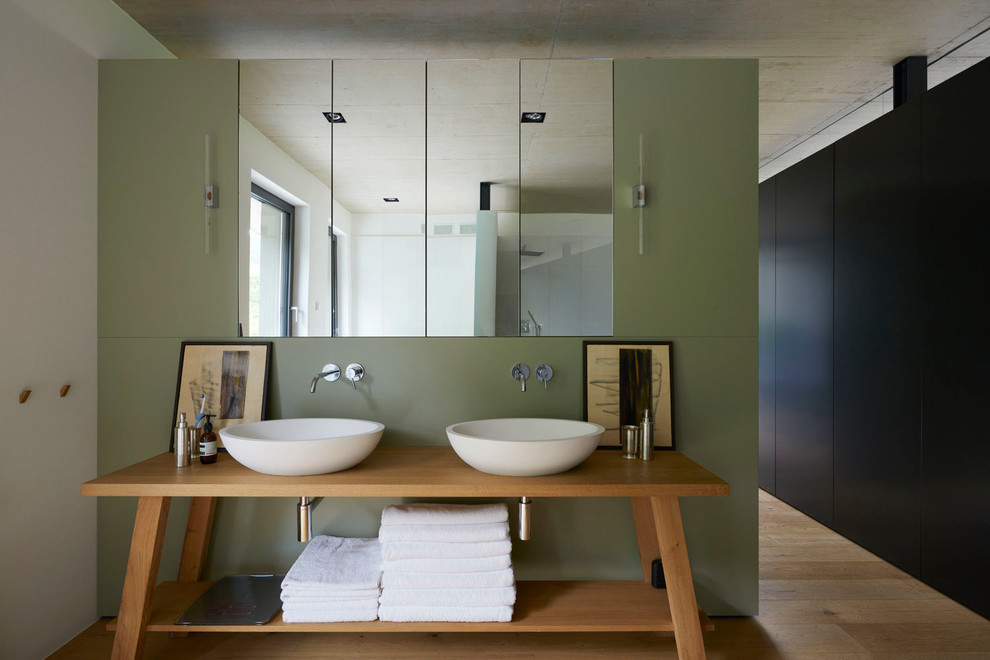 This is an example of a mid-sized contemporary bathroom in Other with medium wood cabinets, medium hardwood floors, a vessel sink and wood benchtops.