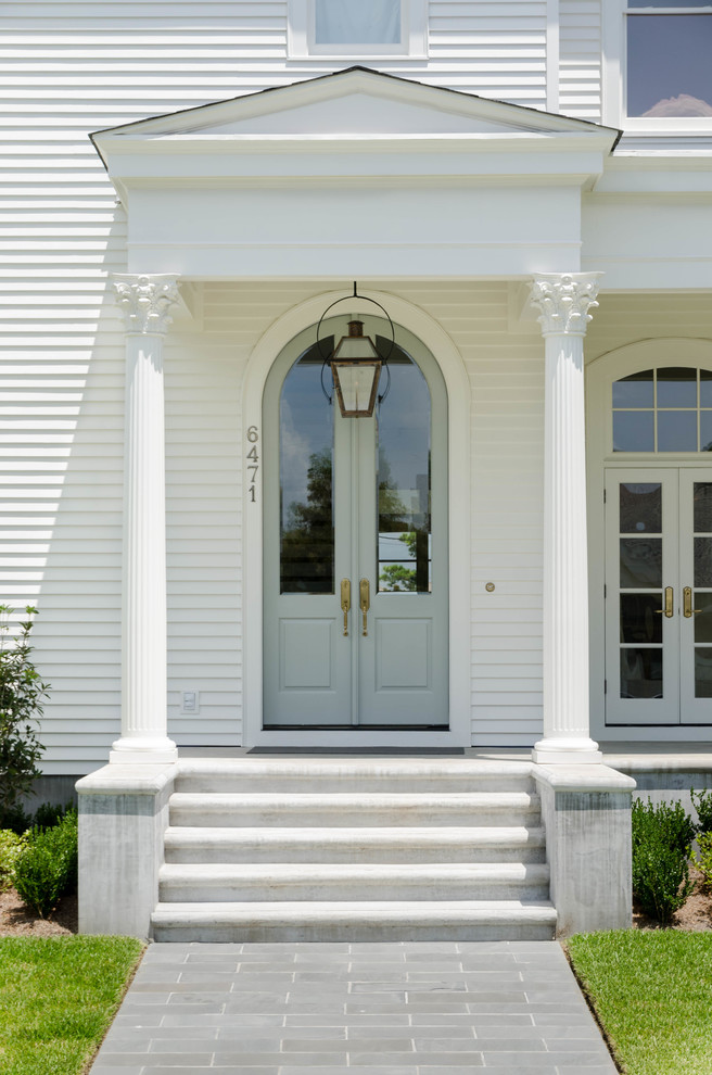 This is an example of a large traditional two-storey white exterior in New Orleans with wood siding.
