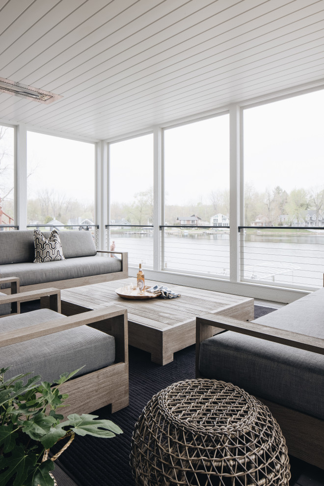 Screened-In Porch - Inspiration for a coastal screened-in and cable railing back porch remodel in Grand Rapids with decking and a roof extension