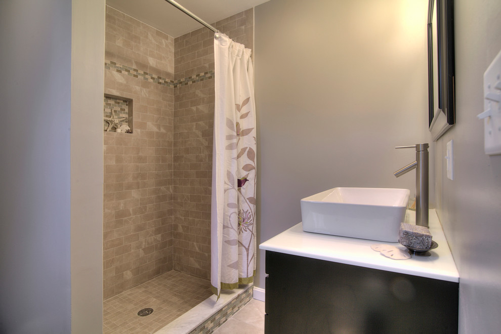 This is an example of a mid-sized modern master bathroom in Boston with furniture-like cabinets, black cabinets, marble benchtops, an alcove shower, a two-piece toilet, gray tile, ceramic tile, grey walls, ceramic floors and a vessel sink.