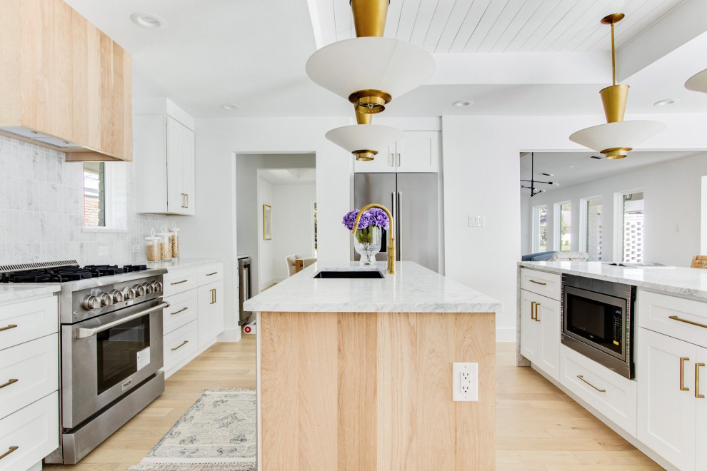 This is an example of an expansive midcentury open plan kitchen in Dallas with a belfast sink, shaker cabinets, white cabinets, white splashback, stainless steel appliances, light hardwood flooring, multiple islands, brown floors, white worktops, a timber clad ceiling, marble worktops and marble splashback.