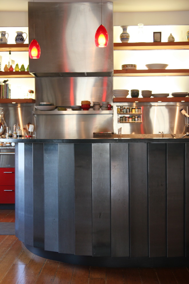 This is an example of an industrial kitchen in San Francisco with open cabinets and metallic splashback.