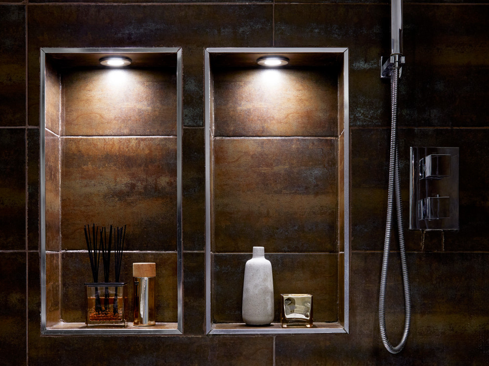 This is an example of a small industrial bathroom in London with flat-panel cabinets, brown cabinets, an alcove tub, a shower/bathtub combo, a one-piece toilet, brown tile, cement tile, grey walls, vinyl floors, a wall-mount sink, wood benchtops, grey floor, a hinged shower door, brown benchtops, a niche, a single vanity and a floating vanity.