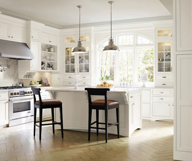 Eat-in kitchen - mid-sized transitional l-shaped light wood floor and brown floor eat-in kitchen idea in Orange County with an undermount sink, white cabinets, granite countertops, beige backsplash, ceramic backsplash, stainless steel appliances, an island and recessed-panel cabinets