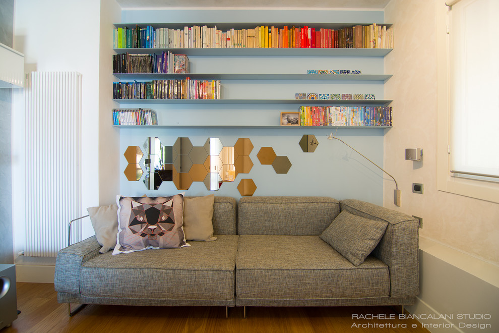 Foto di un soggiorno scandinavo stile loft con libreria, pareti multicolore, parquet chiaro e TV a parete