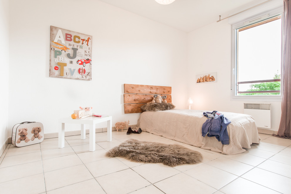 This is an example of a large contemporary gender-neutral kids' bedroom for kids 4-10 years old in Toulouse with white walls and ceramic floors.