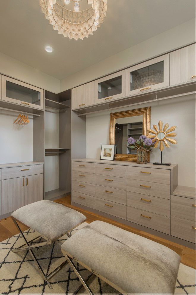 Photo of a transitional gender-neutral dressing room in Austin with flat-panel cabinets, light wood cabinets and medium hardwood floors.