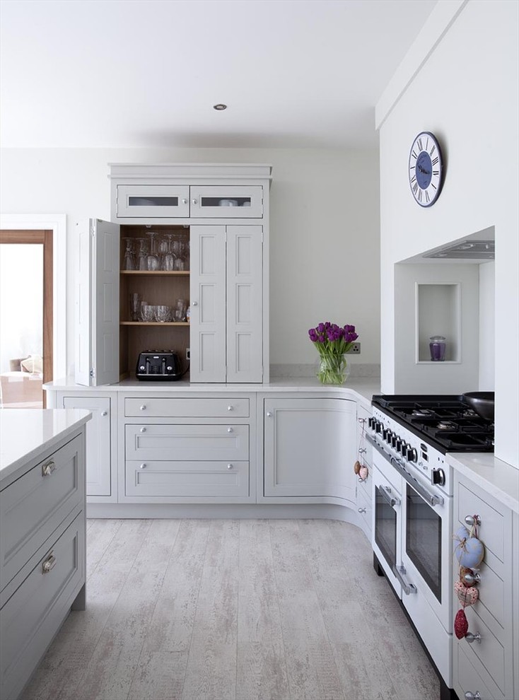 This is an example of a transitional kitchen in Other with recessed-panel cabinets, grey cabinets and white appliances.