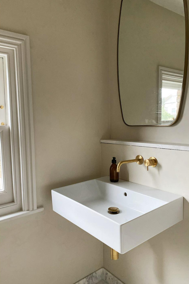 Immagine di una stanza da bagno contemporanea di medie dimensioni con lavabo sospeso, top in marmo, pavimento bianco e top bianco