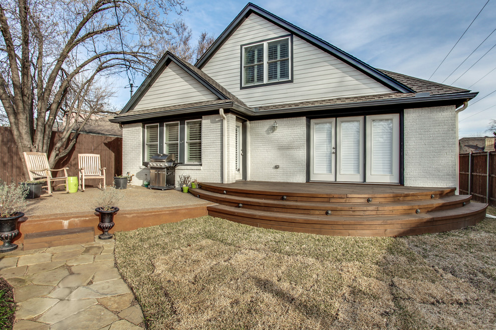 This is an example of a mid-sized transitional backyard deck in Dallas with no cover.