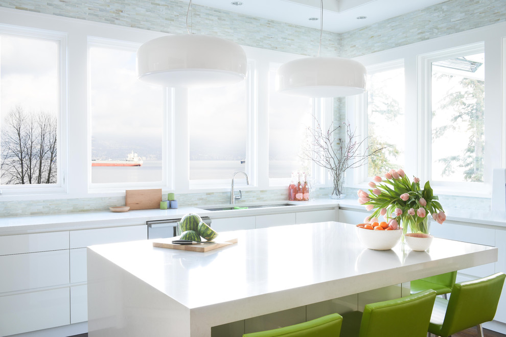 Example of a trendy l-shaped kitchen design in Vancouver with an undermount sink, flat-panel cabinets, white cabinets, stainless steel appliances, an island and white countertops