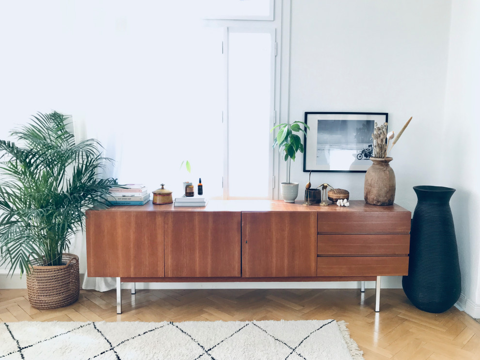 Mittelgroßes, Repräsentatives Mid-Century Wohnzimmer im Loft-Stil mit weißer Wandfarbe, braunem Holzboden, Kaminofen, gefliester Kaminumrandung, TV-Wand und braunem Boden in Hannover