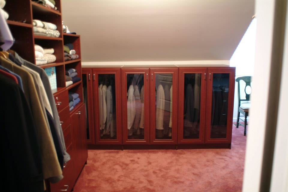 Photo of a small gender-neutral storage and wardrobe in New York with medium wood cabinets.