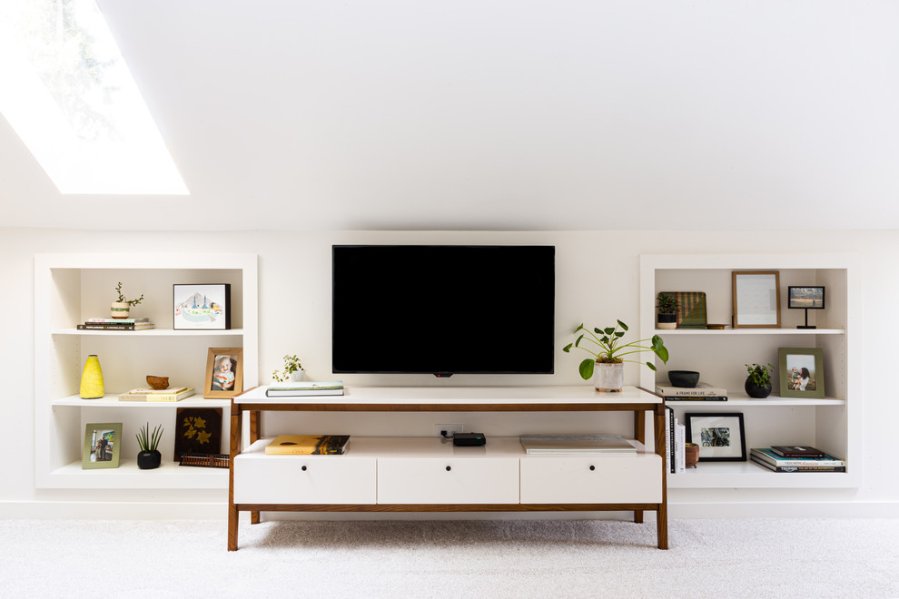 Design ideas for a modern living room in Portland with white walls, carpet, a freestanding tv and grey floor.