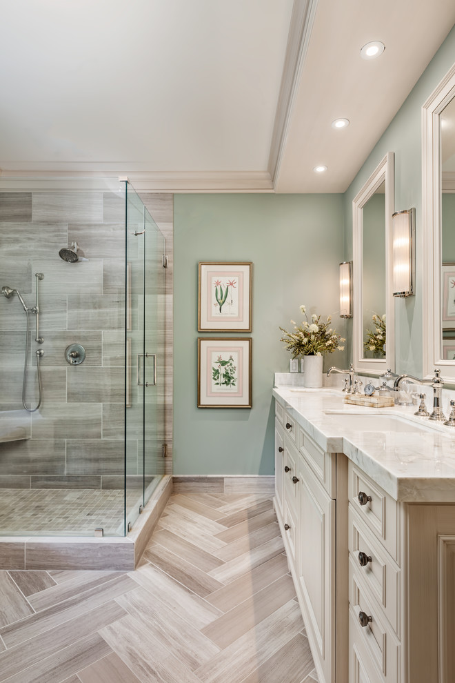 Photo of a transitional bathroom in Other with raised-panel cabinets, white cabinets, a corner shower, gray tile, travertine, an undermount sink, onyx benchtops, grey floor, a hinged shower door and white benchtops.